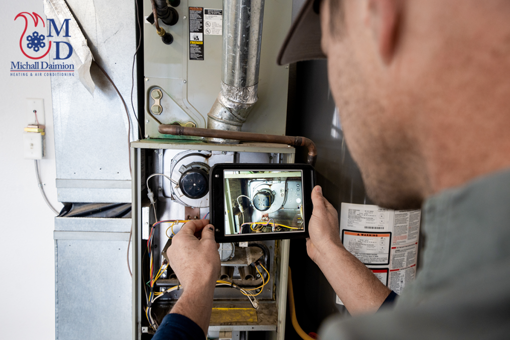 An HVAC tech doing maintenance on a furnace